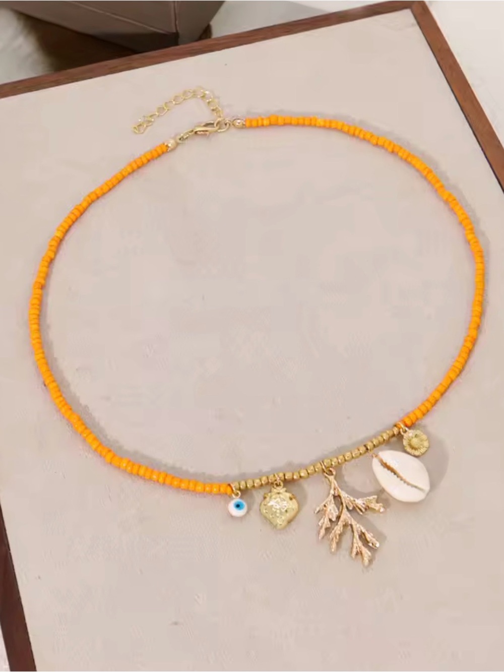 Gold and Orange Beaded Charm Necklace with Shell and Leaf Accents